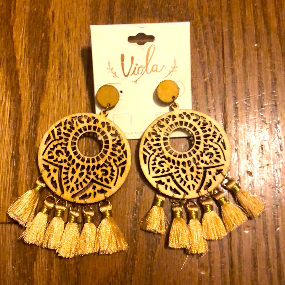New, wooden tan dangle earrings with tan tassels at the the bottom
